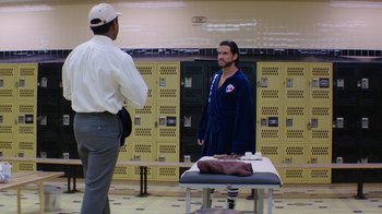 Movie still from “Hands of Stone” (2016), directed by Jonathan Jakubowicz – Two men standing in front of a bed in a room; Medium shot, Over the shoulder angle