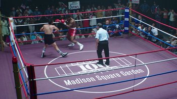 Movie still from “Hands of Stone” (2016), directed by Jonathan Jakubowicz – Two boxers in a boxing ring in front of a crowd; Extreme Wide shot, High angle