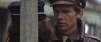 Movie still from “Hanover Street” (1979), directed by Peter Hyams – A man wearing a hat and a tie looking at a cat; Close Up shot, Over the shoulder angle