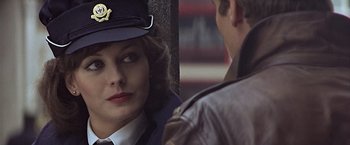 Movie still from “Hanover Street” (1979), directed by Peter Hyams – A woman wearing a hat and a jacket; Close Up shot, Over the shoulder angle