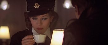 Movie still from “Hanover Street” (1979), directed by Peter Hyams – A woman holding a coffee cup in front of another woman; Close Up shot, Over the shoulder angle