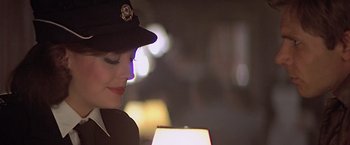 Movie still from “Hanover Street” (1979), directed by Peter Hyams – A person wearing a hat with lights in the background; Close Up shot, Over the shoulder angle