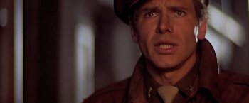 Movie still from “Hanover Street” (1979), directed by Peter Hyams – A person wearing a hat and jacket; Close Up shot, Over the shoulder angle