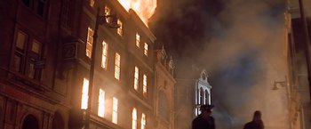 Movie still from “Hanover Street” (1979), directed by Peter Hyams – A building that is on fire with smoke billowing out of it; Wide shot, Low angle