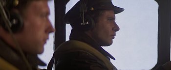 Movie still from “Hanover Street” (1979), directed by Peter Hyams – A person wearing a hat and headphones; Close Up shot, Low angle