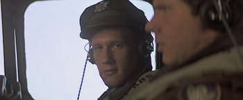 Movie still from “Hanover Street” (1979), directed by Peter Hyams – A man in a military uniform wearing headphones and a hat; Close Up shot, Low angle
