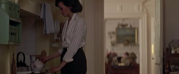 Movie still from “Hanover Street” (1979), directed by Peter Hyams – A woman standing in front of a mirror in a room; Medium shot, Low angle