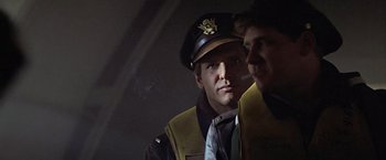 Movie still from “Hanover Street” (1979), directed by Peter Hyams – A man in a pilot's hat and a man in a pilot's vest; Close Up shot, Over the shoulder angle