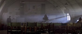 Movie still from “Hanover Street” (1979), directed by Peter Hyams – An empty room with a person sitting on a chair; Extreme Wide shot, Low angle