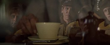 Movie still from “Hanover Street” (1979), directed by Peter Hyams – A man sitting in front of a plate of food; Close Up shot, Over the shoulder angle