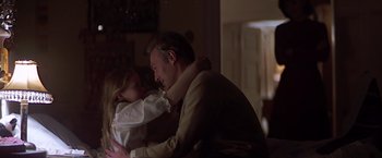Movie still from “Hanover Street” (1979), directed by Peter Hyams – A man and a little girl sitting in a living room; Medium shot, Over the shoulder angle