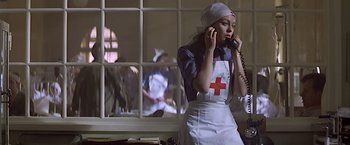 Movie still from “Hanover Street” (1979), directed by Peter Hyams – A woman talking on a phone while wearing an apron; Medium shot, Low angle