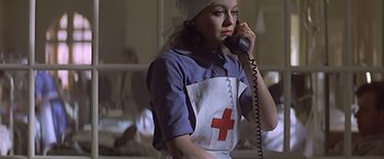 Movie still from “Hanover Street” (1979), directed by Peter Hyams – A woman wearing an apron talking on a phone; Medium shot, Low angle