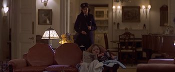 Movie still from “Hanover Street” (1979), directed by Peter Hyams – A woman standing in a living room next to a child reading; Wide shot, Low angle