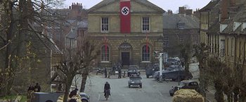 Movie still from “Hanover Street” (1979), directed by Peter Hyams – A group of people standing in front of a building; Extreme Wide shot, High angle