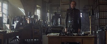 Movie still from “Hanover Street” (1979), directed by Peter Hyams – A man in uniform standing in front of a desk; Wide shot, Low angle