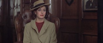 Movie still from “Hanover Street” (1979), directed by Peter Hyams – A woman wearing a hat sitting in a chair; Close Up shot, Over the shoulder angle