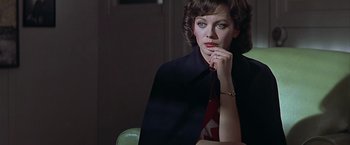 Movie still from “Hanover Street” (1979), directed by Peter Hyams – A woman sitting in front of a green chair in a dark room; Close Up shot, Over the shoulder angle