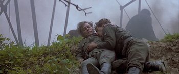 Movie still from “Hanover Street” (1979), directed by Peter Hyams – A man and a boy are laying on the ground; Medium shot, Low angle