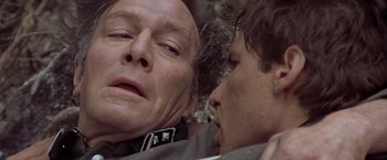 Movie still from “Hanover Street” (1979), directed by Peter Hyams – A man and a woman laying on the ground together; Close Up shot, Low angle