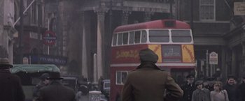 Movie still from “Hanover Street” (1979), directed by Peter Hyams – A red double - decker bus driving down a street; Wide shot, Low angle
