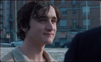 A young man is smiling for the camera