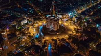 Movie still from “Emily in Paris” (2020), created by Darren Star – An aerial view of the arc de triomphe at night; Extreme Wide shot, High angle