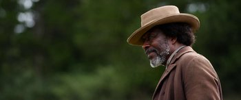 Movie still from “Harriet” (2019), directed by Kasi Lemmons – An older man wearing a brown hat and a brown jacket; Close Up shot, Low angle