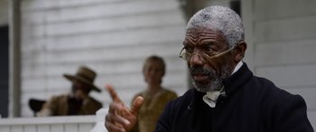 Movie still from “Harriet” (2019), directed by Kasi Lemmons – An older man wearing glasses talking to a woman; Close Up shot, Over the shoulder angle