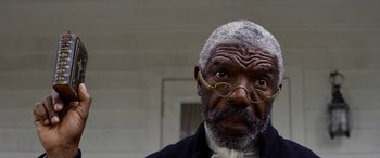 Movie still from “Harriet” (2019), directed by Kasi Lemmons – An older man wearing a suit and glasses; Close Up shot, Low angle