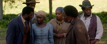Movie still from “Harriet” (2019), directed by Kasi Lemmons – A group of people standing next to each other in a field; Medium shot, Over the shoulder angle