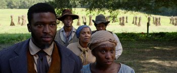 Movie still from “Harriet” (2019), directed by Kasi Lemmons – A group of people standing next to each other in a field; Medium shot, Over the shoulder angle