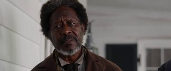 Movie still from “Harriet” (2019), directed by Kasi Lemmons – An older man in a brown jacket looking at the camera; Close Up shot, Over the shoulder angle