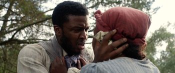 Movie still from “Harriet” (2019), directed by Kasi Lemmons – A man is holding his tie up to a woman's head; Close Up shot, Over the shoulder angle