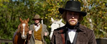 Movie still from “Harriet” (2019), directed by Kasi Lemmons – A man with a long beard wearing a hat; Medium shot, Over the shoulder angle