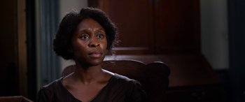 Movie still from “Harriet” (2019), directed by Kasi Lemmons – A woman sitting in front of a wooden wall; Close Up shot, Over the shoulder angle