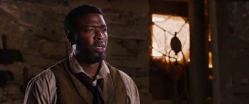 Movie still from “Harriet” (2019), directed by Kasi Lemmons – A man in a brown vest and a brown tie; Close Up shot, Over the shoulder angle