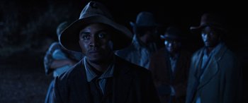 Movie still from “Harriet” (2019), directed by Kasi Lemmons – A group of men standing next to each other in a dark room; Close Up shot, Low angle