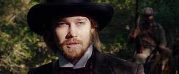Movie still from “Harriet” (2019), directed by Kasi Lemmons – A man with long hair and a beard wearing a hat; Close Up shot, Over the shoulder angle