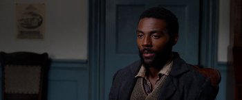 Movie still from “Harriet” (2019), directed by Kasi Lemmons – A man with a beard is standing in front of a door; Close Up shot, High angle