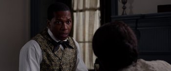 Movie still from “Harriet” (2019), directed by Kasi Lemmons – A man wearing a vest and a bow tie; Close Up shot, Over the shoulder angle