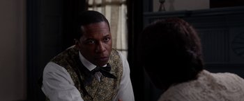 Movie still from “Harriet” (2019), directed by Kasi Lemmons – A man wearing a vest and a bow tie; Close Up shot, Over the shoulder angle