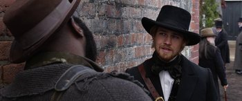 Movie still from “Harriet” (2019), directed by Kasi Lemmons – A man wearing a hat and a bow tie; Close Up shot, Over the shoulder angle