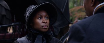 Movie still from “Harriet” (2019), directed by Kasi Lemmons – A woman in a black dress and a black hat holding an umbrella; Close Up shot, Over the shoulder angle