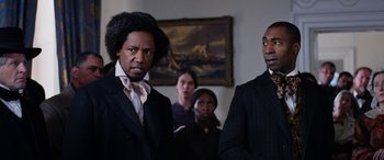 Movie still from “Harriet” (2019), directed by Kasi Lemmons – A group of people standing in front of a painting; Close Up shot, Over the shoulder angle