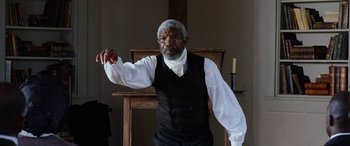 Movie still from “Harriet” (2019), directed by Kasi Lemmons – An older man wearing a black vest and a white shirt; Medium shot, High angle