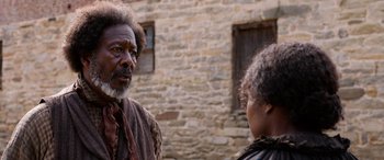 Movie still from “Harriet” (2019), directed by Kasi Lemmons – An older man and a younger woman standing next to each other; Close Up shot, Over the shoulder angle