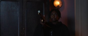 Movie still from “Harriet” (2019), directed by Kasi Lemmons – A woman holding a wooden stick in a dark room; Medium shot, Over the shoulder angle