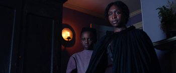 Movie still from “Harriet” (2019), directed by Kasi Lemmons – A woman standing next to a young boy in front of a light; Medium shot, Low angle