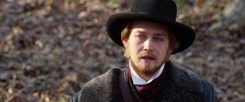 Movie still from “Harriet” (2019), directed by Kasi Lemmons – A man with a long beard wearing a black hat; Close Up shot, Over the shoulder angle
